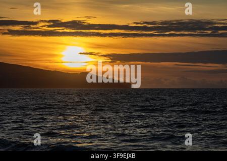 Luftaufnahme eines goldenen Sonnenuntergangs über der Küste und dem dunklen Wasser von Praia do Areal de Santa Barbara, Ribeira Grande, Acores, Portugal. Stockfoto