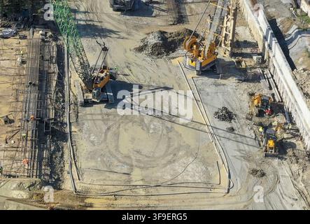 Luftaufnahme einer großen Baustelle mit schweren Kränen, gelben Baggern und Arbeitern auf schlammigem Boden in Istanbul, Istanbul, Turkiye. Stockfoto