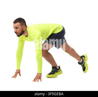 Maler Athlet in neongelber Sportbekleidung in Startblock-Position, bereit zum Laufen, isoliert auf weißem Hintergrund Stockfoto