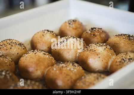 Frisch gebackene, handwerklich hergestellte Sauerteigbrötchen mit Weizensauerteig-Vorspeise, garniert mit Sesam, Mohn und alles, was gewürzt wird. Perfekt für Stockfoto