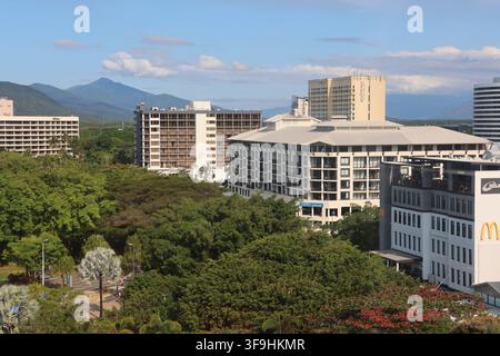 Eine Luftaufnahme aus hohem Winkel über mehrstöckige Hotelgebäude und grüne Stadtbäume hinweg zu den Bergen im Hintergrund in Cairns, Queensland, Australien Stockfoto