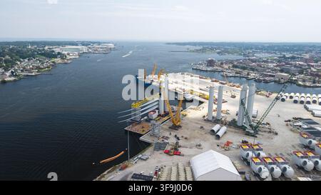 Luftbild der Windturbinen-Baustelle im Hafen mit großen Turbinenblättern, Turmsegmenten und Kränen am Ufer in New London, Conne Stockfoto
