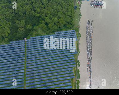 Luftaufnahme des Sirajganj-Kraftwerks mit umfangreichen Solarpanelanlagen neben einem Fluss mit schwimmenden Strukturen im Bezirk Sirajganj, Rajs Stockfoto