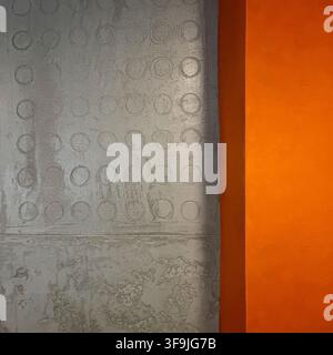 Dekorativer grauer Putz-Zementstoff mit orangefarbenem Rand an einer Wand im Innenraum Stockfoto