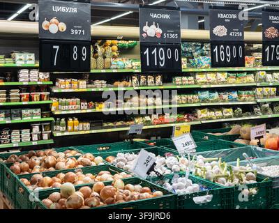 Kiew, Ukraine – 14. März 2026: Gemüse ist in Kisten ordentlich angeordnet in einem örtlichen Lebensmittelgeschäft mit Reihen von verpackten Waren auf den Regalen dahinter zu Stockfoto