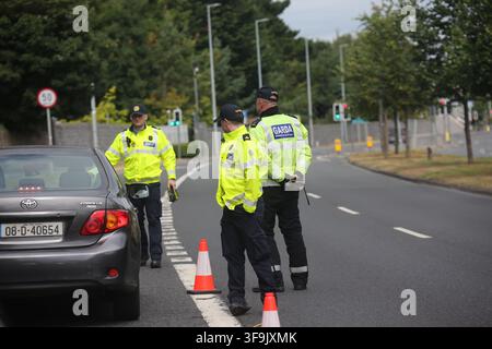 Clondalkin, Dublin, Irland, 15. Aug. 2026 – Ein markiertes Garda Roads Policing SUV, ein uniformierter Garda-Beamter in Warnkleidung, Verkehrskegel und ein zweisprachiges Garda Seicphointe Checkpoint-Schild sind auf der R113 positioniert. Die Gardaí richteten eine Straßenkontrolle auf der Strecke durch Clondalkin ein; der spezifische Zweck der Operation und etwaige Durchsetzungsmaßnahmen wurden nicht mitgeteilt. Das Bild dokumentiert die Verkehrskontrolle, Verkehrsmanagement und öffentliche Sicherheitsüberwachung im Vorort von Dublin. Die R113 führt durch Clondalkin. Stockfoto