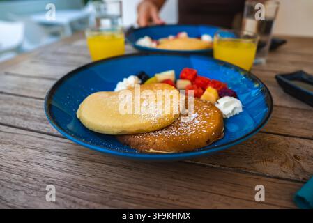 Frische Pfannkuchen, serviert mit Obst und Saft an einem Tisch Stockfoto