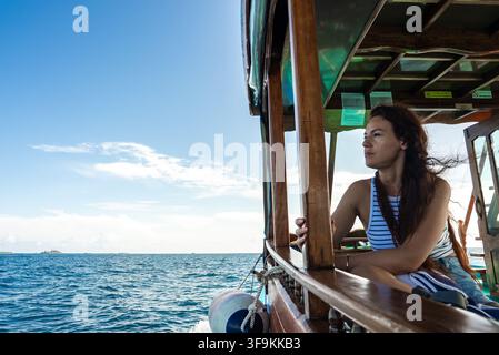 Frau genießt eine Holzbootfahrt auf dem Meer auf den Malediven Stockfoto