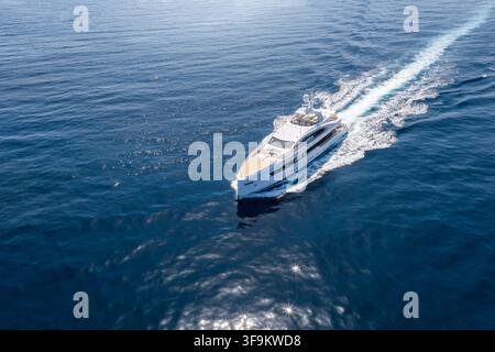 Luftaufnahme eines modernen Luxusyachts, der mit hoher Geschwindigkeit über ruhiges Meer fährt Stockfoto
