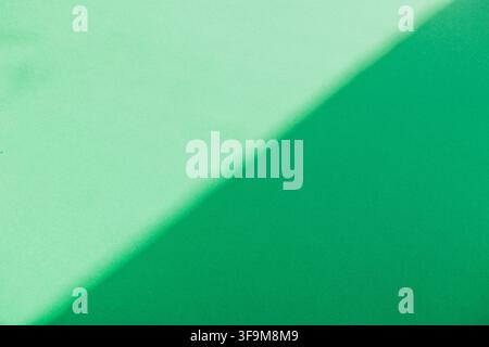 Abstrakter minimalistischer zweifarbiges grünes Hintergrundmotiv mit einem weichen diagonalen Schatten, der helles Mintgrün und sattes Smaragdgrün trennt. Perfektes Dualfarben-Ge Stockfoto