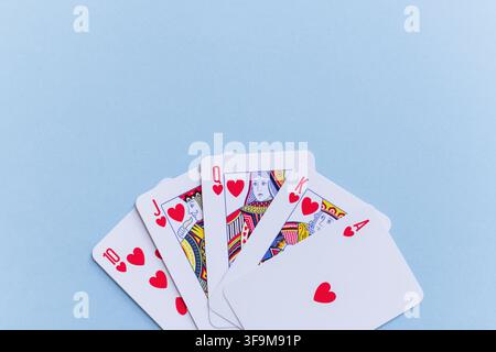 Royal Flush Herzen Spielkarten aufgefächert auf einem hellblauen Hintergrund mit Kopierraum. Minimalistisches Flat Lay, das Glück, Erfolg, Gewinnen und p darstellt Stockfoto