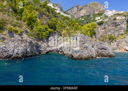 Natürliche Steinbogen-Felsformation im Meer mit Küstenklippen und Bergen, Conca dei Marini, Italien Stockfoto