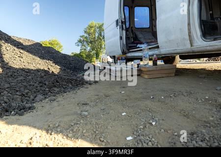Baubaustellenszene mit Arbeitswagen und Materialien Stockfoto