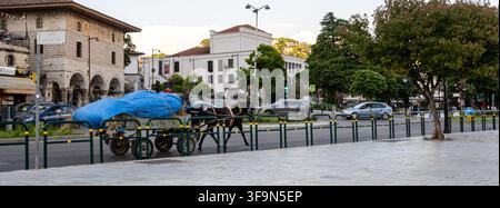 Berat, Albanien, 17. Juni 2026. Ein traditioneller Pferdewagen steht auf einer belebten Straße und präsentiert lebhafte blaue Planen. Diese malerische Szene fängt die Essenz der lokalen Kultur ein, während die Sonne untergeht. Stockfoto