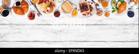 Oberseite für Frühstück oder Brunch auf einem weißen Holzbannerhintergrund. Ansicht von oben. Auswahl an süßen und herzhaften Lebensmitteln. Stockfoto