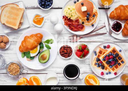 Frühstücks- oder Brunch-Tischszene auf einem weißen Holz-Hintergrund. Oberansicht. Auswahl an süßen und herzhaften Speisen. Stockfoto