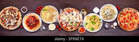 Köstliche italienische Essensszene auf dem Tisch. Vielzahl von Pizzen und Nudeln. Ansicht von oben auf einem dunklen Holztischhintergrund. Stockfoto