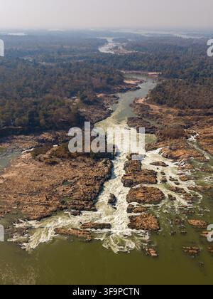 Hohe Luftaufnahme der Khone Phapheng-Wasserfälle, die den Mekong-Fluss zeigen, der durch freiliegende Felsschluchten stürzt. Stockfoto