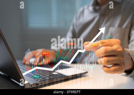 Geschäftsinvestor analysiert Aktienhandelsdaten auf einem Laptop mit Kerzencharts, Kauf- und Verkaufssignalen und einem aufsteigenden Pfeil, der Finanzen und Investitionen veranschaulicht Stockfoto