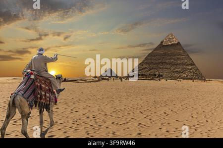 Ein beduine auf einem Kamel vor den Pyramiden von Gizeh Stockfoto