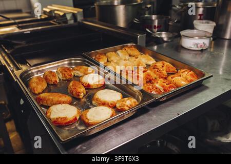 Leckere frisch gebackene, aromatische Brötchen aus süßem Teig, die auf einem großen Metallgericht in der Bäckereiküche stehen. Sieht köstlich aus, lecker. Layi Stockfoto