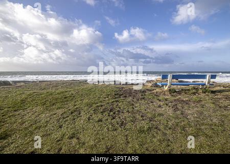 Mächtige Atlantikwellen schlagen gegen felsige Klippen entlang der Küste der Bretagne in Frankreich. Unter einem strahlend blauen Sommerhimmel glitzern das Meer und die schroffe Küste Stockfoto