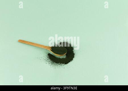 Grüne Algen in Pulverform - Chlorella, Spirulina im Löffel auf hellem Hintergrund. Stockfoto