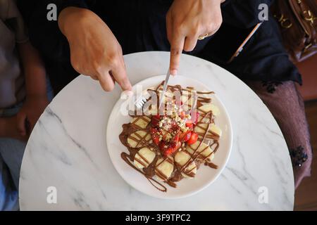 Waffel mit Erdbeeren auf einem Marmortisch essen Stockfoto