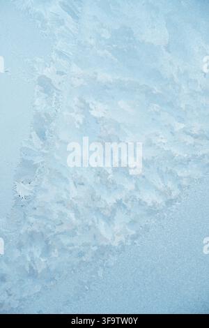 Schöne frostige Muster auf einem blauen Fenster Stockfoto
