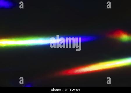 Abstrakte Regenbogenlichtstreifen auf dunklem Hintergrund: Bunte Spektrumreflektionen Stockfoto