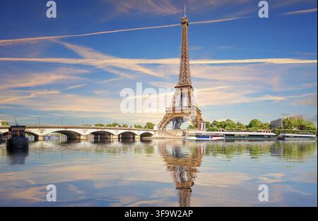 Berühmtes Wahrzeichen von Paris, der Eiffelturm über der Seine mit Brücke, Blick bei Sonnenuntergang, Frankreich Stockfoto