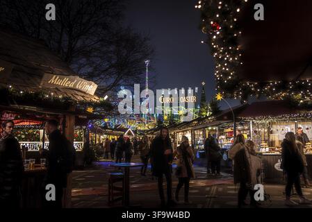 LONDON, ENGLAND, 28. Dezember 2018: Personen, die einen angenehmen Aufenthalt in einer Weihnachtsmarkt, umgeben von Essen und Trinken steht, mit Lichtern dekoriert Stockfoto