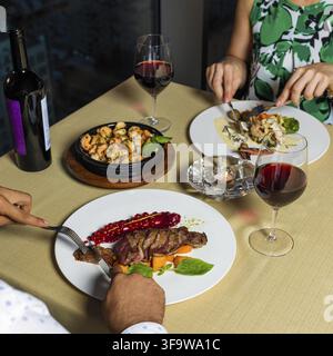 Pärchen beim Abendessen, Steak, Meeresfrüchte und Wein Stockfoto