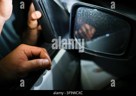 Ein Autospiegel wird mit Hand und Tuch gereinigt, Nahaufnahme der Fahrzeugwartung und sorgfältigen Oberflächenpflege Stockfoto
