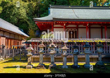 Teilansicht eines traditionellen Holzgebäudes am Tamukeyama Hachimangu-Schrein mit Stehlaternen in Nara Stockfoto