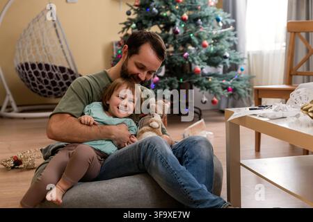 Vater umarmt seine glückliche Tochter zu Weihnachten Stockfoto