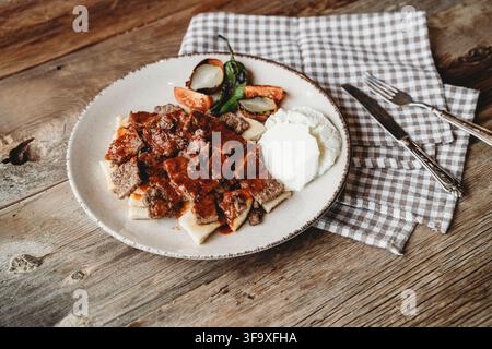 Traditioneller türkischer Iskender-Kapsalon auf einem Teller serviert Stockfoto