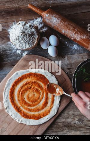 Frische hausgemachte Pizza auf einem Holztisch zubereiten Stockfoto