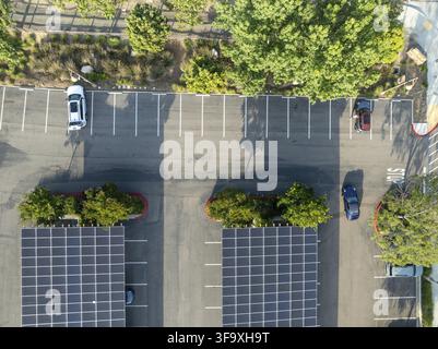 Luftaufnahme von Solarpanelen, die als Schattendach über einem Parkplatz für geparkte Autos installiert wurden. Photovoltaik-Technologie, die in städtische Infrastruktur integriert ist. Stockfoto