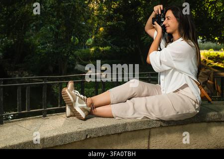 Junge Frau genießt Freizeit beim Fotografieren im Freien Stockfoto