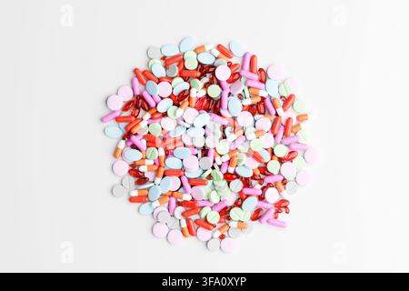 Großer sortierter Stapel farbenfroher Pillen, Kapseln, Tabletten und Weichgel-Kapseln auf weißem Hintergrund, repräsentierend Medizin und Gesundheitswesen. Stockfoto