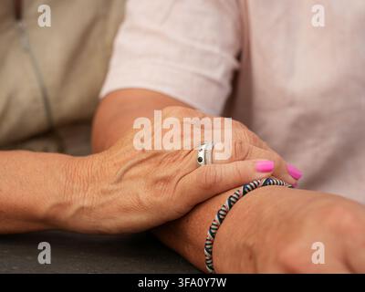 Nahaufnahme eines Seniorenehepaars, das Zuneigung und Zusammengehörigkeit ausdrückt, während eine Frau sanft den Arm ihres Partners berührt, was Liebe, Unterstützung, Vertrauen und Stockfoto
