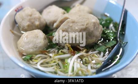 Indonesische Bakso-Fleischballsuppe mit Bohnensprossen anstelle von Nudeln, serviert in klarer Brühe mit Blattgemüse. Stockfoto
