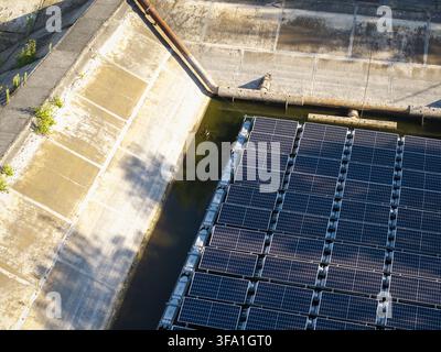 Luftaufnahme von schwimmenden Solarpanelen, die auf einem Wasserreservoir mit Betonböschungen in Polen installiert sind. Stockfoto