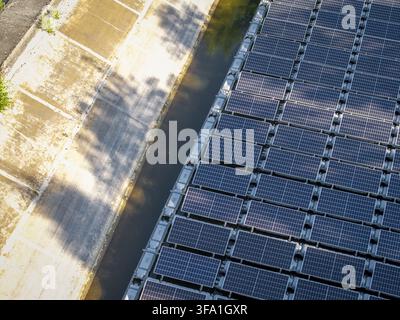 Luftbild von schwimmenden Solarpanelen, die auf einer Wasseroberfläche mit einem Betonufer in Polen installiert sind. Stockfoto