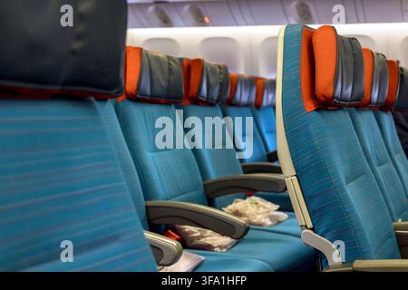 Passagiere warten in einer Flugzeugkabine, während die Flugbesatzung sich auf die Abflugsitze vorbereitet, moderne Innenatmosphäre Stockfoto