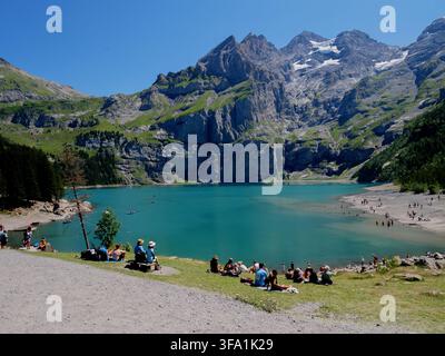 Touristen entspannen sich im Urlaub am türkisfarbenen Seeuferstrand, Alpiner Bergort, Schweiz Stockfoto