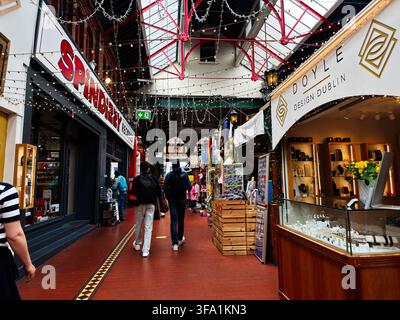 Dublin, Irland - 22. Mai 2026: Belebte Indoor-Marktgasse in Dublin, Irland, mit Einkäufern, die Geschäfte, Stände, Schmuck und Dekoration durchstöbern. Stockfoto