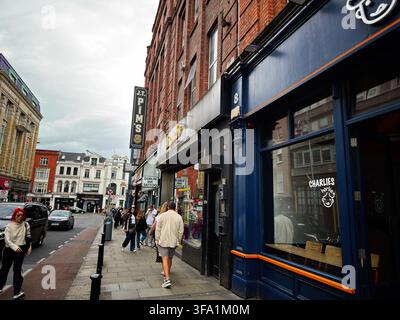 Dublin, Irland - 22. Mai 2026: Überfüllter Dubliner Bürgersteig mit Einkäufern, Schaufenstern und Verkehr, der die urbane Energie und das Alltagsleben in Irland vermittelt. Stockfoto