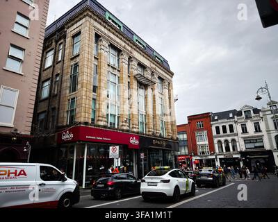 Dublin, Irland - 22. Mai 2026: Historisches Eckgebäude in Dublin mit Spar-Ladenfront, Gelato-Café, Straßenverkehr und Fußgängern. Stockfoto